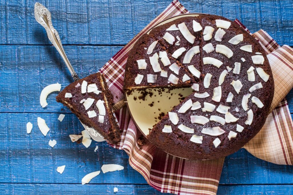 G&acirc;teau au chocolat et &agrave; la noix de coco moelleux, pr&eacute;sent&eacute; sur une assiette avec des copeaux de coco.
